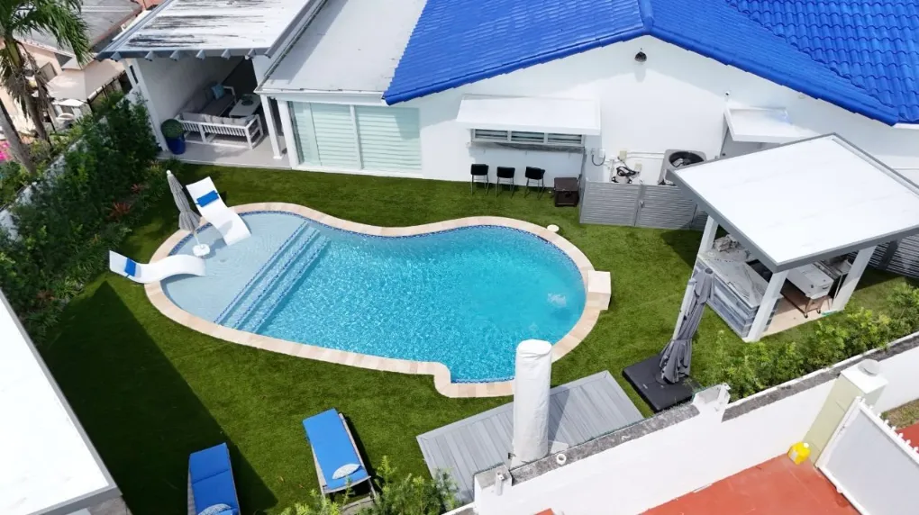 Aerial view of backyard pool surrounded by artificial turf
