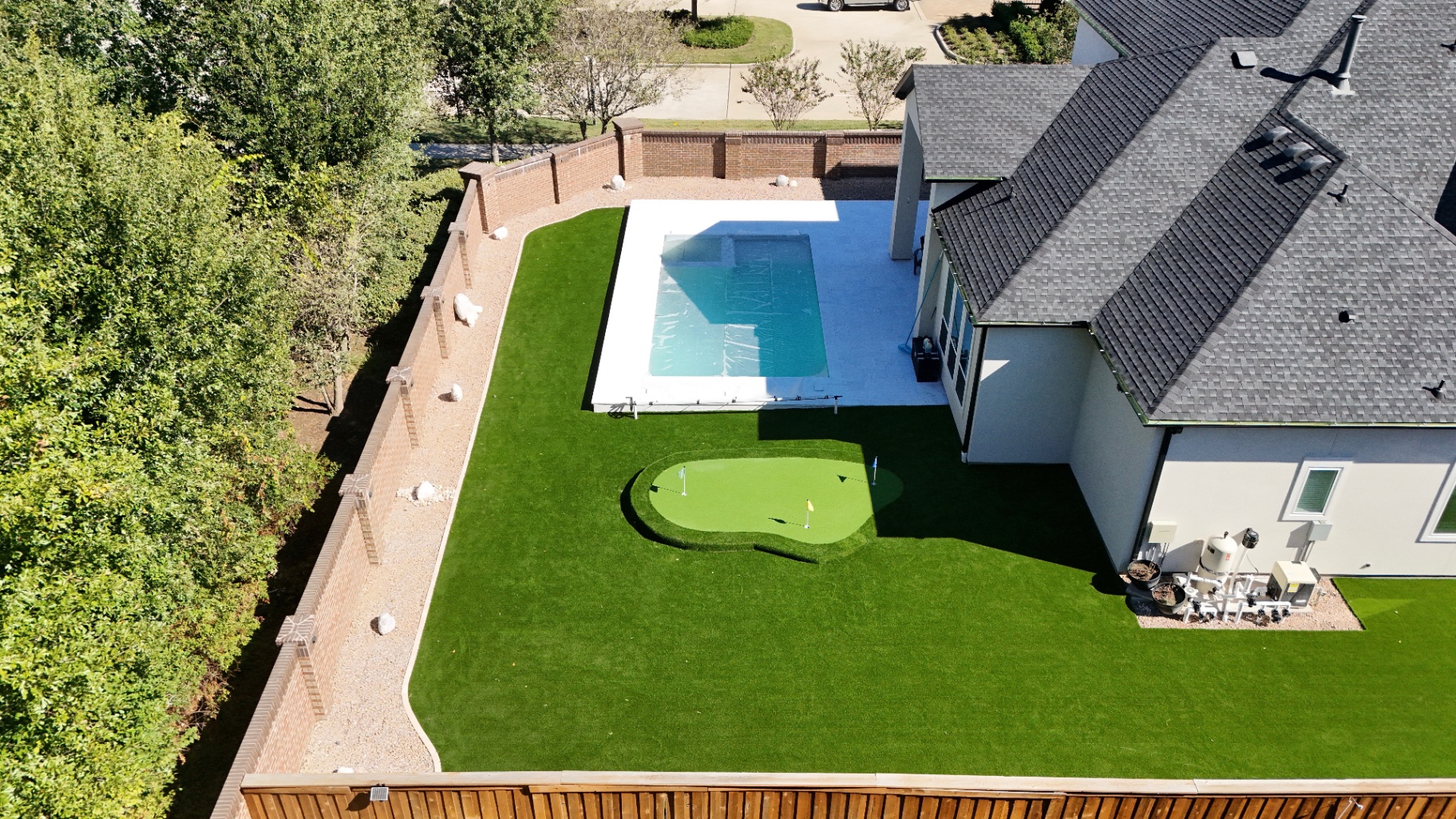 Aerial view of Houston backyard with full artificial turf lawn, putting green and pool