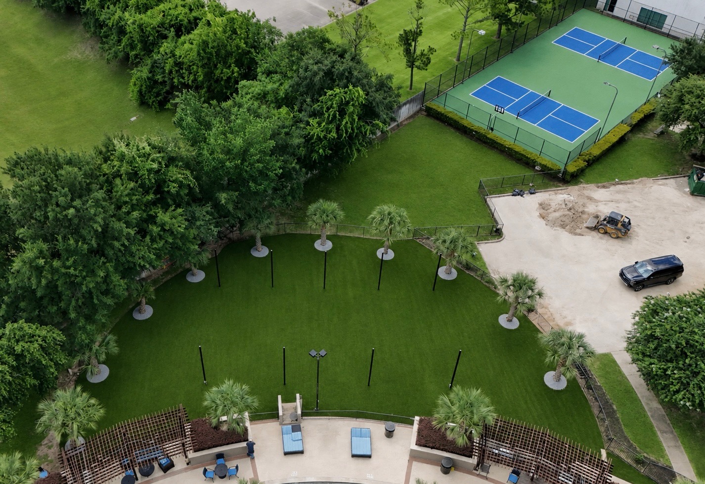 Aerial view of commercial amenity lawn with artificial turf, palm trees and adjacent pickleball courts