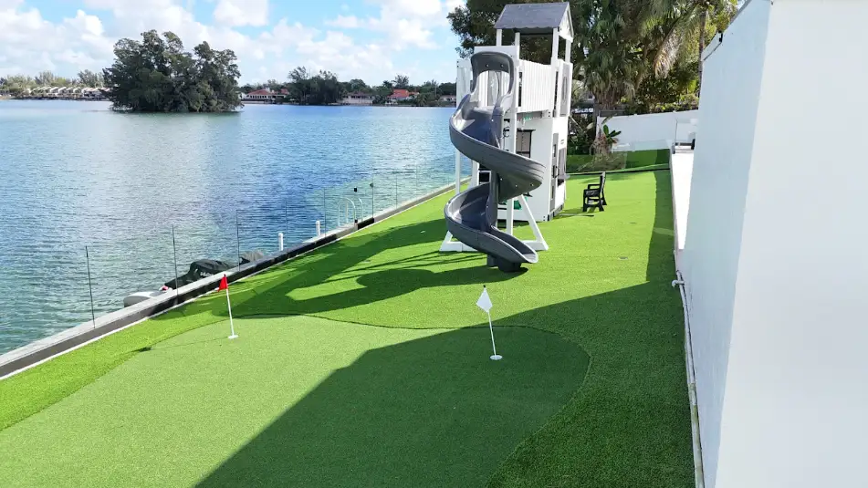 Waterfront putting green with playset on artificial turf